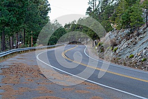 Mountain road in early morning sunrise on hills or cliff in remote lonely location in forest with dirt rest stop area