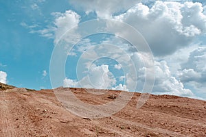 Mountain road going up above the cliff with volumetric clouds.