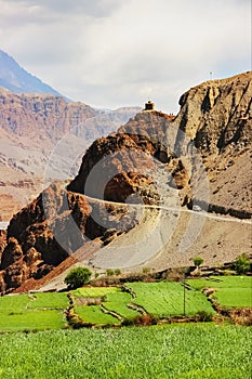 Mountain road and green fields in a mountain gorge. Nepal. The Himalayan mountains. Kingdom of `Lower Mustang`. Trekking in the vi