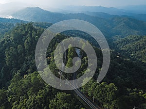 Mountain road in green forest rainy season