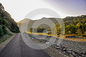 Mountain road landscape with rocks, sunny sky with clouds