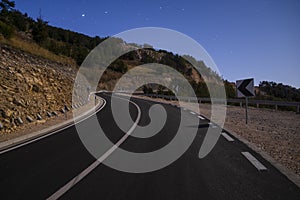 mountain road at night illuminated by the light of the full moon