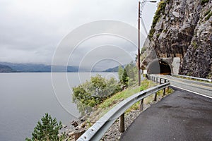 Mountain road in Norway. The entrance to the tunnel and sea view with fog