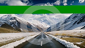 Mountain Road Through Scenic Landscape with Snow-Capped Peaks and Clear Blue Sky