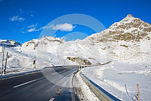 Mountain road in Swiss alps at sunny winter day, Julier Pass, Graubunden, Switzerland. Julier Pass - mountain pass in Switzerla photo