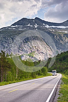 Mountain, road trip and truck in forest with travel, holiday and countryside scenery in Norway. Nature, clouds in sky