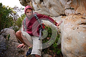Mountain, rock climbing and man hiking in nature with backpack for adventure for wellness in trip. Earth, fitness and