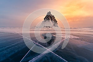 Mountain rock on frozen water lake with sunset tone