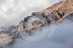 Mountain rocks covered by clouds