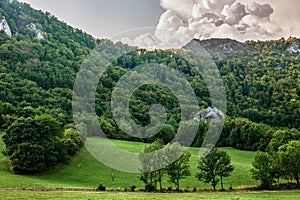 Summer mountain landscape with rock and big white cloud.