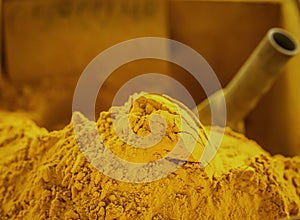 Mountain of scented golden tumeric spice powder displayed at a local farmers market in Sicily