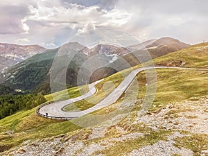 Mountain serpentine in the Alps. An empty road against the backdrop of mountains and cloudy skies. Europe