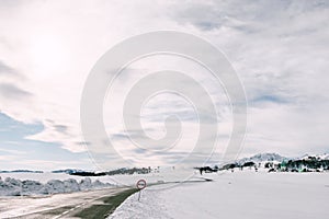 Mountain serpentine road in winter among the snow-covered plains with a view of the forest and mountains.