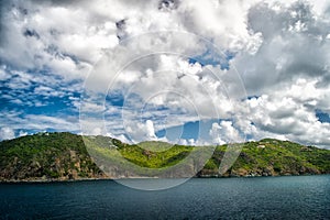 Mountain shore in blue sea on cloudy sky in gustavia, st.barts. Summer vacation on tropical island. Wild nature and environment, e