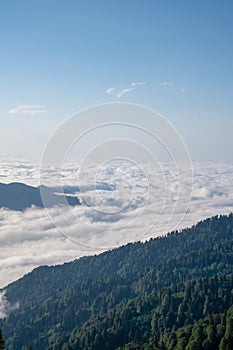 Mountain silhouette above the clouds at sunrise, view from the top view of mountains.