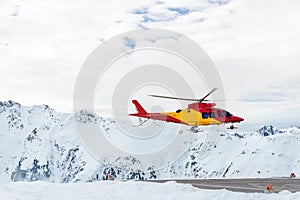 Mountain ski life rescue medic helicopter taking-off from station helipad to search injured skiers and help at accident. Emergency