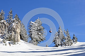 Mountain ski slope, skier and cable car