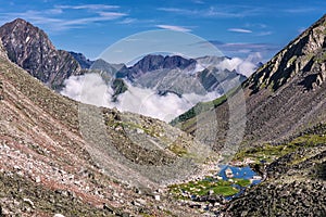 Mountain slopes with stone talus and a small lake photo
