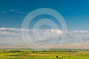 Mountain Small Ararat behind a cloud and green field, beautiful landscape