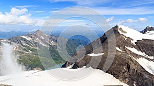 Mountain snow and glacier panorama with summit Kitzsteinhorn and Klockerin and reservoir Wasserfallboden in Glockner Group,