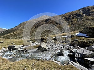 Mountain stream Aua da Grialetsch in the beautiful autumn setting of the alpine valley Val Grialetsch of the Albula Alps massif