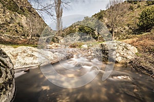 Mountain stream cascading under an ancient Genoese bridge in Cor