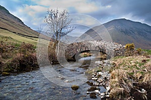 Mountain Stream flowing under a stone bridge