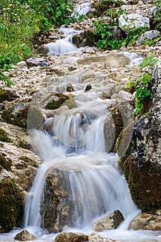 The mountain stream flows throw the stones with a beautiful flow