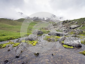 Mountain stream and snow capped peak near col de vars in haute provence