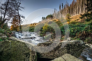 Mountain stream with waterfall in an autumn