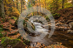 Mountain stream with waterfall in an autumn forest.