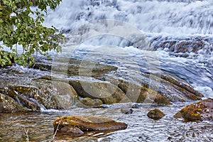 Mountain stream and waterfall rushing down over rocks and boulders. Beautiful nature landscape natural, fresh river