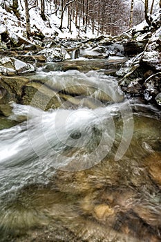 Mountain stream in winter scenery. Prowcza Stream, Bieszczady National Park, Carpathian Mountains, Poland. One of the most popular