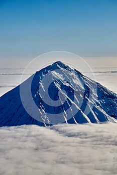 Mountain sunny landscape. Mountain peak over white thick clouds.