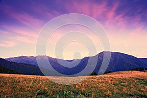 Mountain sunrise with pink and violet clouds