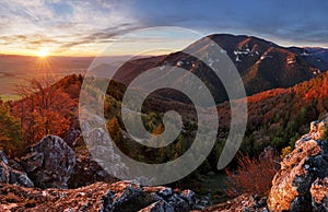 Mountain at sunset with sun and forest