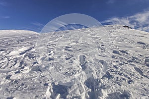 Mountain top view in winter. Ski routes in the mountains. Snowy winter mountain background.