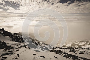 Mountain tops in autumn covered in mist or clouds - soft vintag