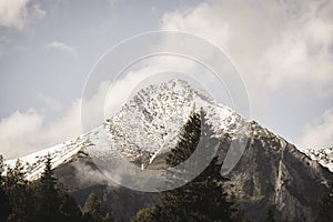 Mountain tops in autumn covered in mist or clouds - soft vintag