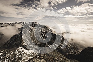 Mountain tops in autumn covered in mist or clouds - soft vintag