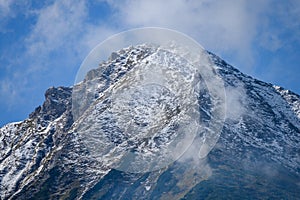 Mountain tops in autumn covered in mist or clouds in sunny day