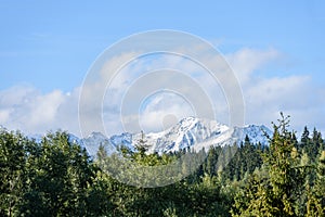 Mountain tops in autumn covered in mist or clouds in sunny day