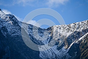 Mountain tops in autumn covered in mist or clouds in sunny day