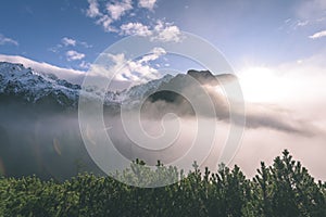 Mountain tops in autumn covered in mist or clouds in sunny day-