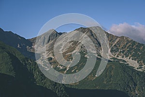 Mountain tops in autumn covered in mist or clouds in sunrise li