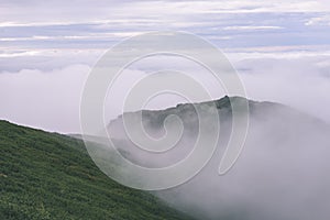 Mountain tops in autumn covered in mist or clouds- vintage effe