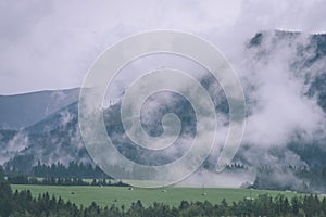 Mountain tops in autumn covered in mist or clouds- vintage effe