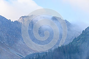 Mountain tops in autumn covered in mist or clouds