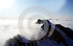 Mountain tops protrude from the clouds photo