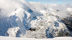 Mountain tops in winter covered in snow with bright sun and blue